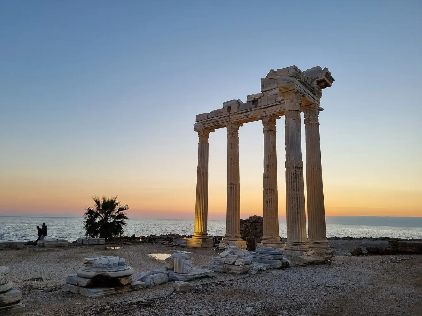 De Apollotempel van Side bij zonsondergang met een palm aan de waterkant