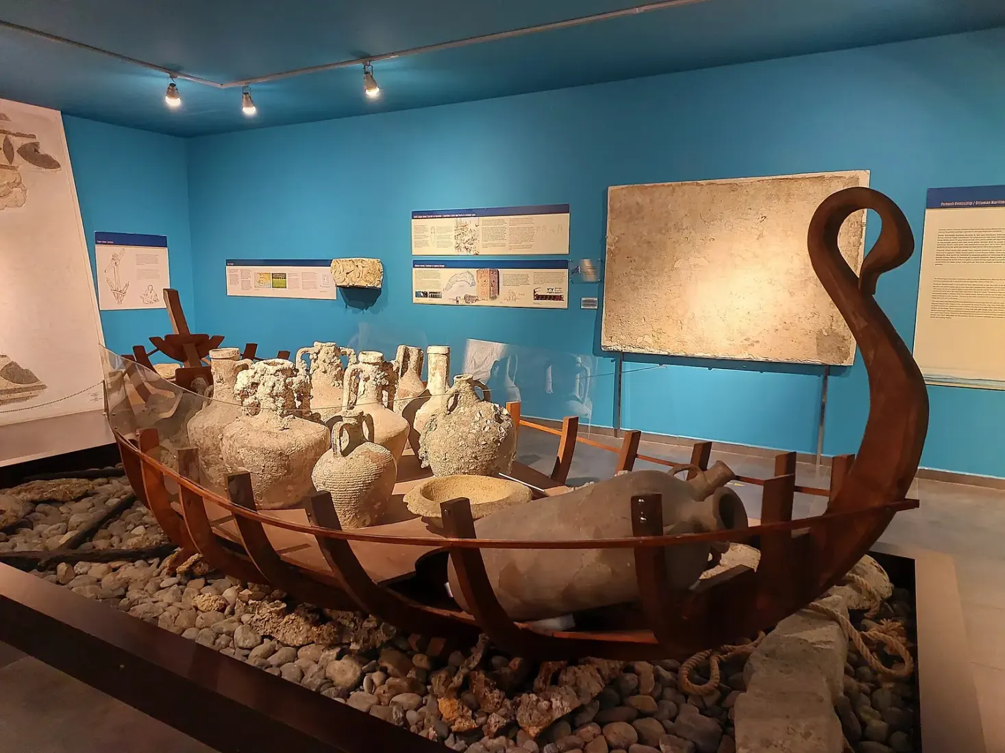 Een scheepsmodel vol amforen in de zaal over handel over zee