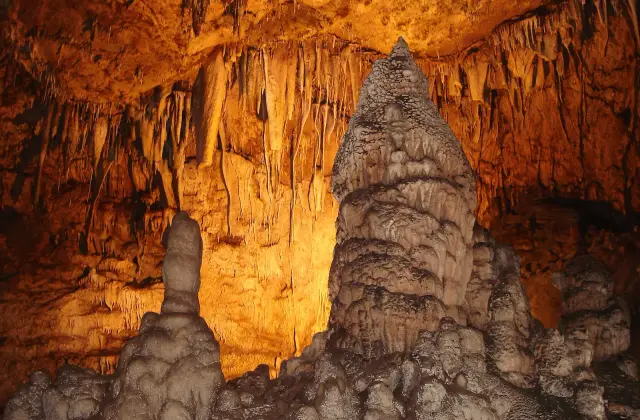 Hoge druipsteenpilaren in warm licht in de Dim grot boven Alanya