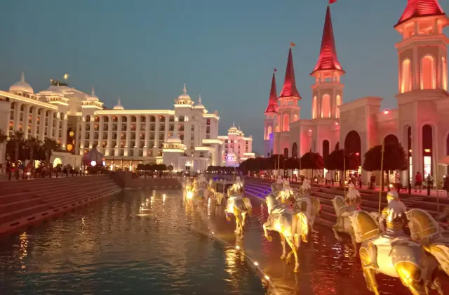 Het sprookjeskasteel en de fontein met paardenbeelden van The Land of Legends in Belek bij avondlicht