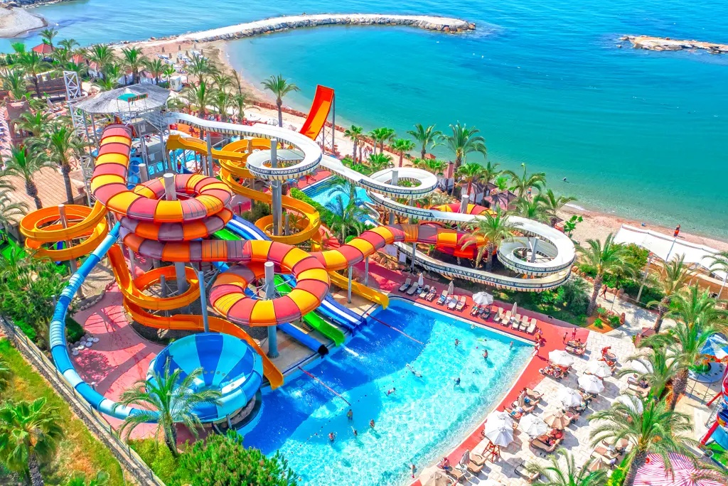 Aquapark van Long Beach Alanya met kleurrijke waterglijbanen naast de zee.