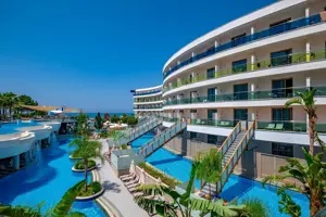 Buitenkant van Long Beach Alanya met hotelgebouw en zwembaden.