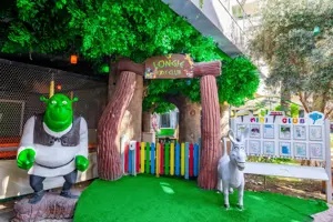 Kinderclub of speelgedeelte in Long Beach Alanya met een dinosaurus bij de entree.