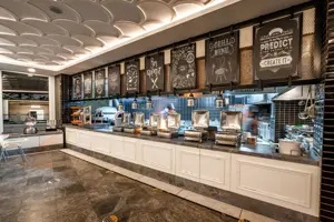 Patisserie of buffetgedeelte in Long Beach Alanya met toonbank en zitplekken.