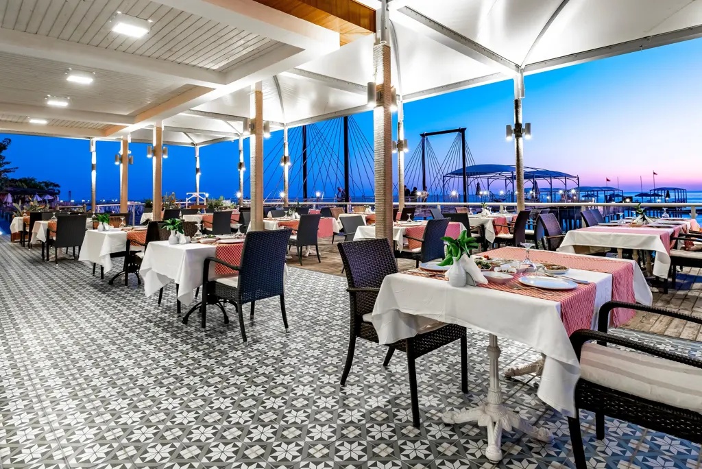 Restaurantterras van Long Beach Alanya in de avond met uitzicht richting zee.