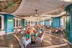 Restaurant in Long Beach Alanya met turquoise interieur en ronde tafels.