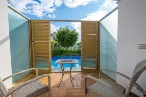 Terras bij Long Beach Alanya met stoelen en een klein privézwembad.