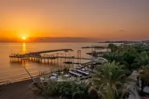 Zonsondergang bij de pier en zee van Long Beach Alanya.